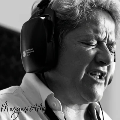Cantante con audífonos interpretando un tango frente a un micrófono de condensador en estudio, fotografía en blanco y negro